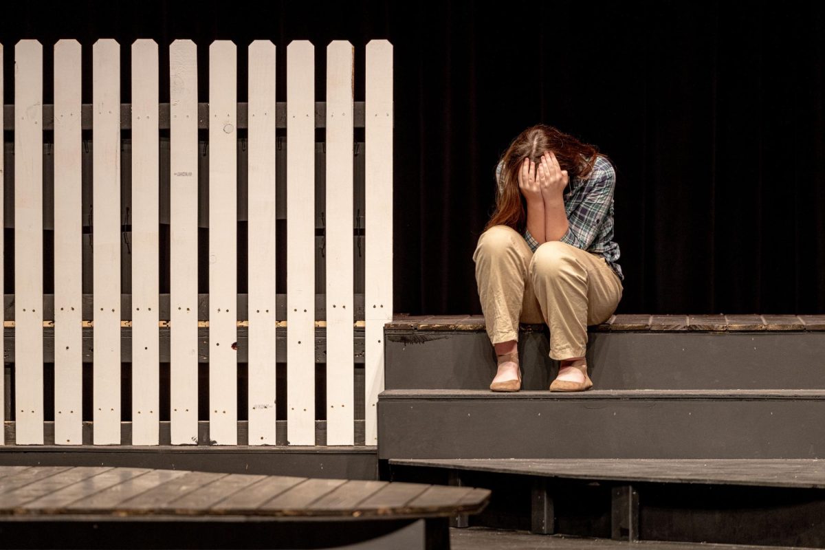 Nora Dunbar slumps over, her head in her hands as she grieves for those who lost their lives during the Sandy Hook shooting. Dunbar played Kat and Sally. 
On Nov. 7 and 8, the drama department performed "26 Pebbles," a play that focusses on how Newtown, Connecticut dealt with the trauma of what was one the worst school shootings in American history. In the district, the play sparked community backlash as parents took to social media with their concerns. The Growl takes a deeper look at the controversy and how Sandy Hook changed how Americans deal with national tragedies. 